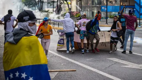 EPA Riot police fired tear gas and rubber bullets at protesters in Caracas as thousands demonstrated against the outcome of Sunday's presidential poll