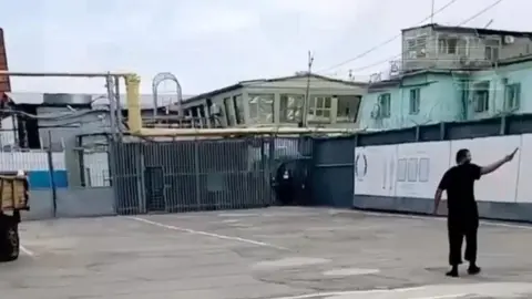 baza In this frame from an unverified video posted on social media, a man is shown holding a knife, apparently in a courtyard within the IK-19 Surovikino facility