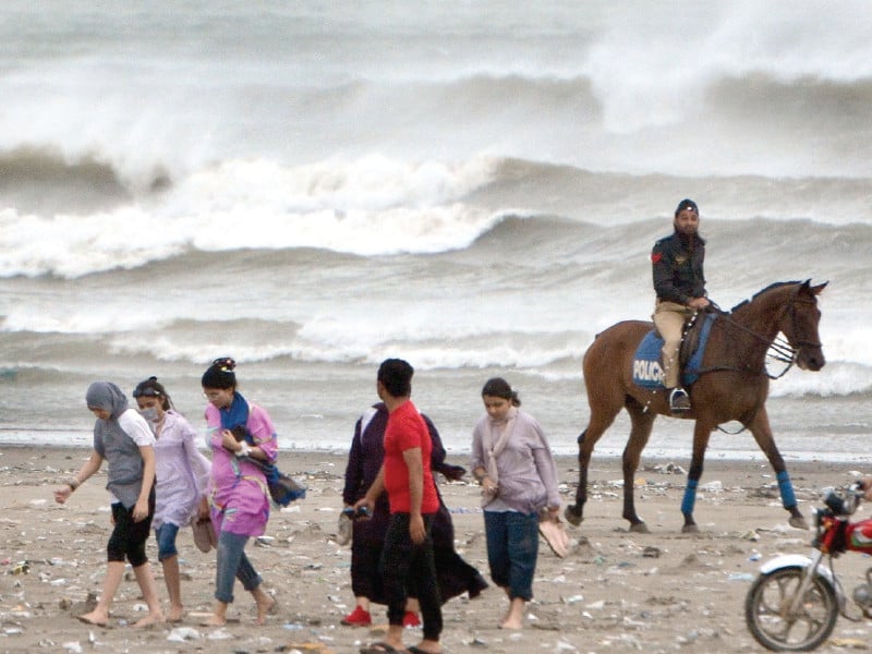 horse mounted police tell people to move away from the sea view beach on friday due to threat of being washed away in high tides caused by cyclone asna photo jalal qureshi express