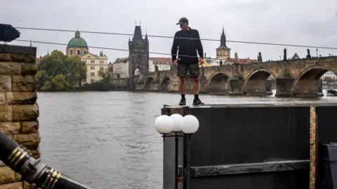   MARTIN DIVISEK/EPA-EFE/REX/Shutterstock A worker prepares to close an anti-flood gate on Vltava river in the city center of Prague, Czech Republic, 13 September 2024