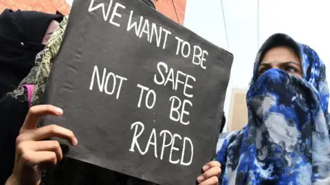 Getty Images TOPSHOT - A Kashmiri demonstrator holds a placard during a protest calling for justice following the recent rape and murder case of an eight-year-old girl in the Indian state of Jammu and Kashmir, in Srinagar on April 16, 2018. - Eight men accused of raping and murdering an eight-year-old girl pleaded not guilty April 16 to the horrific crime that has sparked revulsion and brought thousands to India's streets in protest. (Photo by TAUSEEF MUSTAFA / AFP) (Photo by TAUSEEF MUSTAFA/AFP via Getty Images)