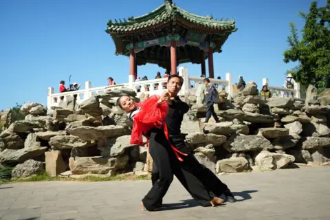 Dancers in Ritan Park in front of a traditional Chinese pagoda