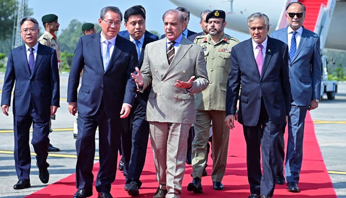 Prime Minister Shehbaz Sharif (right) walks with his Chinese counterpart Li Qiang as he arrives at Nur Khan Airbase in Rawalpindi, on October 14, 2024. — PMO