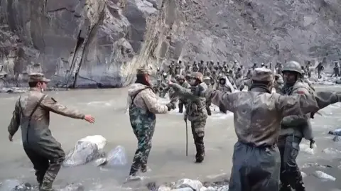 Getty Images This video frame grab taken from footage recorded in mid-June 2020 and released by China Central Television (CCTV) on February 20, 2021 shows Chinese (foreground) and Indian soldiers (R, background) during an incident where troops from both countries clashed in the Line of Actual Control (LAC) in the Galwan Valley, in the Karakoram Mountains in the Himalayas