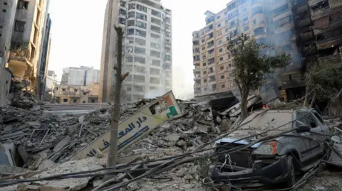 Reuters Damaged buildings and a destroyed vehicle following an Israeli air strike on Beirut, Lebanon. Photo: 27 October 2024