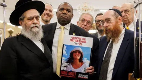 Reuters David Lammy pictured holding an image of Emily Damari 