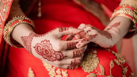 Getty Images A stock photo of an unrecognizable woman holding a ring in preparation for her wedding