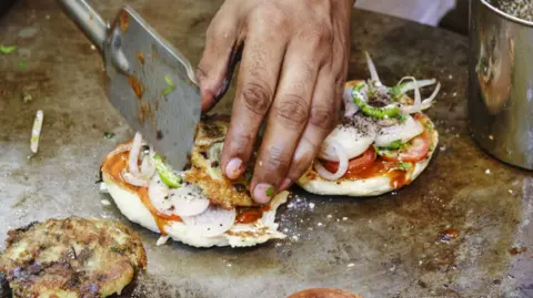 Getty Images Cook preparing vegetarian burgers in Varanasi, Uttar Pradesh, India, Asia