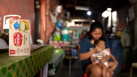 BBC/ Pritam Roy Cerelac box with mother feeding son the infant cereal