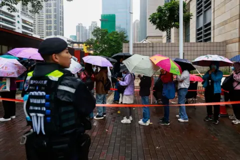 Getty Images Heavy police presence is seen as huge crowds queue up for public gallery seats, ahead of a sentencing hearing for 45 pro-democracy activists, outside a court in Hong Kong, China, on November 19, 2024. 