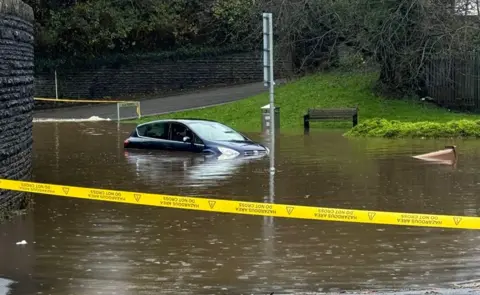 Kelly Jones Cordon around flood water with a vehicle partly submerged