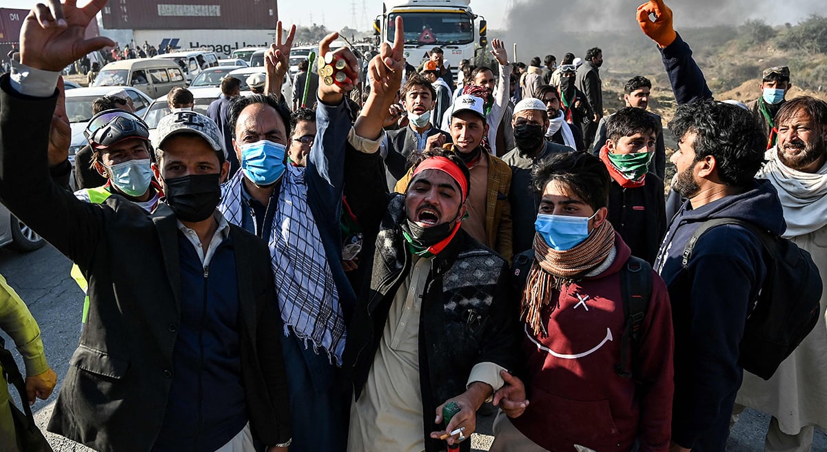 Supporters of jailed former prime minister Imran Khan´s Pakistan Tehreek-e-Insaf (PTI) party shout slogans as they march towards Islamabad after clearing shipping containers placed by authorities during a demonstration demanding Khan´s release, in Hasan Abdal in Punjab province on November 25, 2024. —  AFP