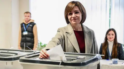 DANIEL MIHAILESCU/AFP Moldovan President and candidate for Party of Action and Solidarity (PAS) party Maia Sandu casts her ballots for the presidential election and referendum on joining the European Union, at a polling station in Chisinau on October 20, 2024