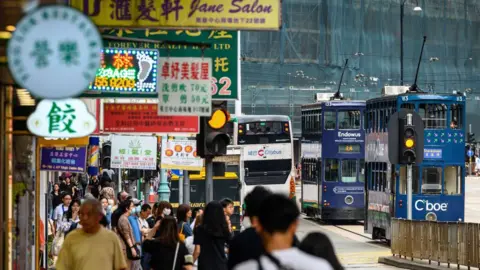 Getty Images A view of a tram rumbling down the main street of the North Point district in Hong Kong on November 9, 2024. The pavement is crowded with people. 