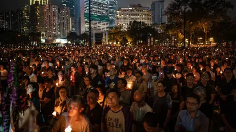 Getty Images People hold candles as they take part in a candlelight vigil at Victoria Park on June 4, 2019 in Hong Kong, China.