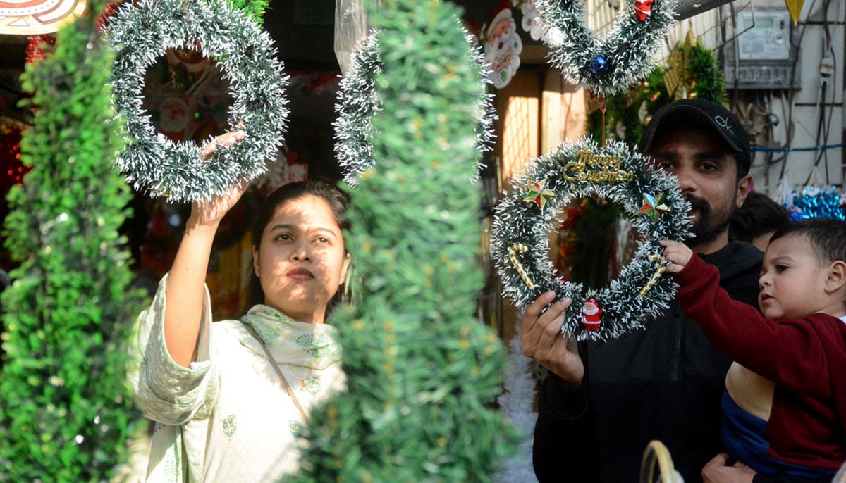 A family enthusiastically shopping for Christmas essentials at Bohri Bazar in Karachi on December 21, 2024. — APP