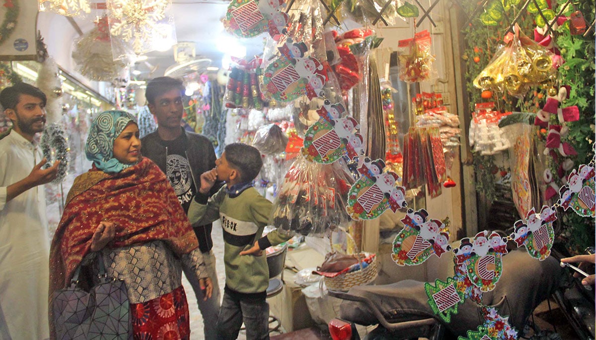 A family is pictured while buying Christmas decorative items to celebrate Christmas in Islamabad on December 23, 2024. — Online