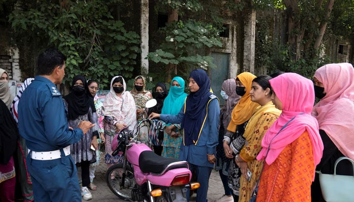 A Traffic wardens familiarise a group of women with components of a motorbike, during a training session as part of the Women on Wheels program organised by the traffic police department in Lahore on October 1, 2024. — Reuters