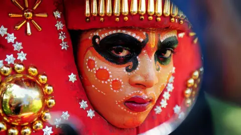 AFP An Indian 'Theyyam' artist with his face painted waits to perform during the 'Kummati Kali' as part of the annual Onam festival celebrations in Thrissur district of southern Kerala state on September 15, 2016. The Theyyam worship rituals are part of several thousand year-old traditions and customs celebrated in Kerala state