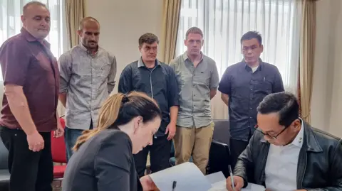 EPA 'Bali Nine' (L-R, background) Martin Eric Stephens, Michael William Czugaj, Scott Anthony Rush, Matthew James Norman and Si Yi Chen inside a room in Bali International Airport during a handover process for their return