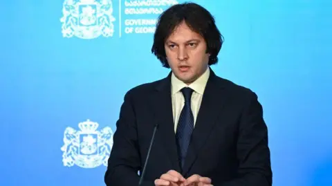 VANO SHLAMOV/AFP Georgia's prime minister addresses a daily briefing and vows action will be taken against protest organisers