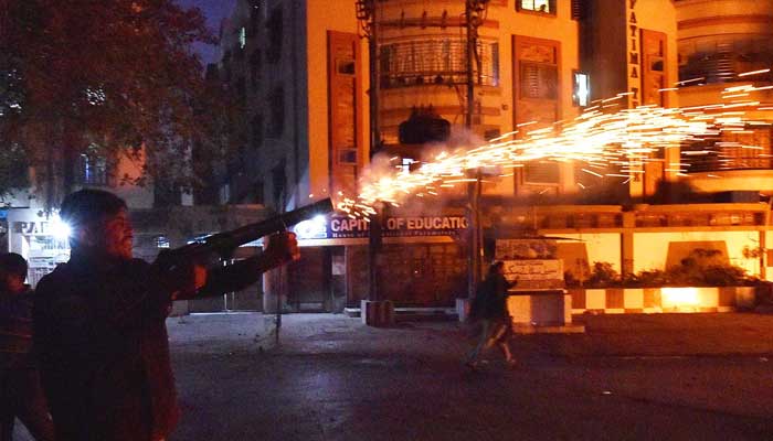 Police personal fire tear gas shell after clash between police and MWM protesters at Numaish Chowrangi. — INP