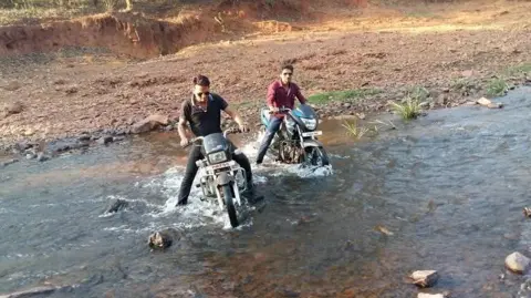 Ganesh Mishra Ganesh Mishra (left) and Mukesh Chandrakar navigating difficult terrain on bikes while on their way to report a story