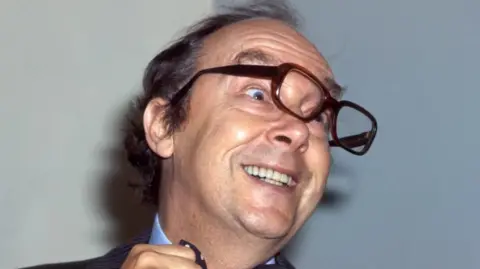 BBC Eric Morecambe, wearing a bow tie, laughing and with his glasses askew, 07/12/1979.