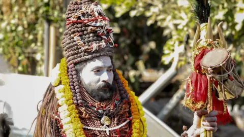 Ankit Srinivas An ash-smeared Hindu holy man holding a trident at the Kumbh Mela festival in Prayagraj in January 2025