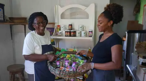 Gemma Handy Novella Payne and her granddaughter Jenna Reid hold up a basket containing some of the products they make