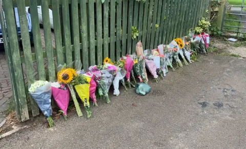 Floral tributes in a line