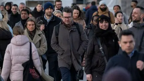 Getty Images A crowd of people commuting to work on a winter's morning