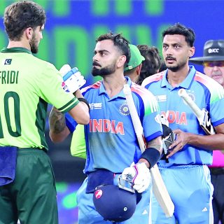 pakistani pacer shaheen shah afridi congratulates indian batsman virat kohli as india s axar patel looks on on their team s victory in the icc champions trophy one day international cricket match at the dubai international stadium photo afp