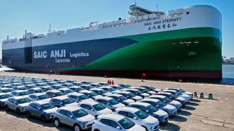 Getty Images This aerial photograph taken on May 15, 2024 shows cars for export waiting to be loaded on the "SAIC Anji Eternity"a domestically manufactured vessel intended to export Chinese automobiles, at Yantai port, in eastern China's Shandong province.