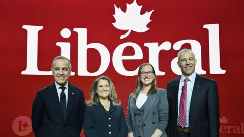 Getty Images Candidates vying for Liberal Party leadership pose before Monday's debate in front of a large Liberal Party banner 