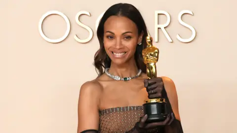 Getty Images Zoë Saldaña, winner of the Best Actress In A Supporting Role for “Emilia Pérez”, poses in the press room