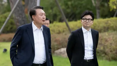 News 1 South Korean president Yoon Suk Yeol walks alongside Han Dong-Hoon in a garden