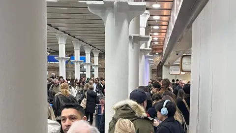 Crowd of passengers in Eurostar area at St Pancras International station