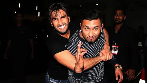 Getty Images Ranveer Singh (L) wearing a black tshirt and blue jeans and Honey Singh (R) wearing a black and white stripped sweatshirt and blue jeans at the Zee Cine Awards 2014 in Mumbai