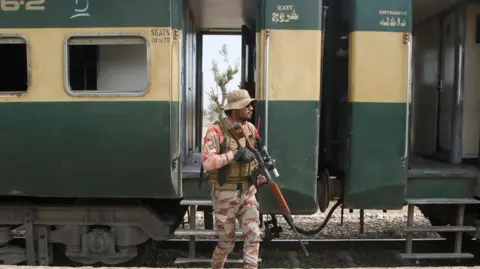 Reuters A Pakistan Army soldier stands guard next to a rescue train