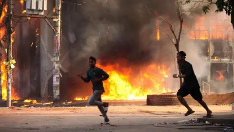 Getty Images A garment store is reportedly set ablaze by a group of unidentified miscreants in Dhaka on August 4, 2024. 