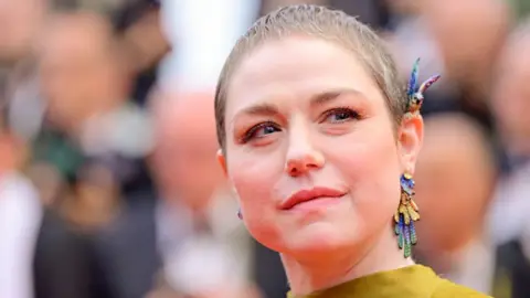 Getty Images Émilie Dequenne with short hair and colourful earrings on the red carpet at the 2024 Cannes Film Festival