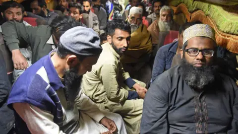 AFP Train passengers sit in a bus after being freed by armed militants who ambushed the train in the remote mountainous area of southwestern Balochistan province