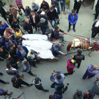 the bodies of victims killed in israeli airstrikes are carried on a horse cart outside al ahli arab hospital in gaza photo afp