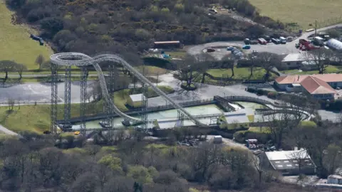 Getty Images An aerial view of the ride Drenched (formerly Hydro) at Oakwood Theme park in Pembrokeshire on April 9, 2016 in Narberth, United Kingdom. The theme park is home to rides including Megafobia, Vertigo and Speed. There are trees surrounding the buildings and rides. 