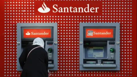 Getty Images Santander customer taking money out of a cash machine