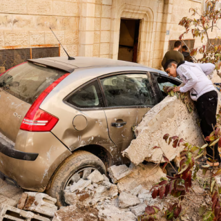 palestinians stand near a damaged vehicle near the site where a number of palestinians were killed in an israeli raid in jenin in the israeli occupied west bank march 11 2025 photo reuters